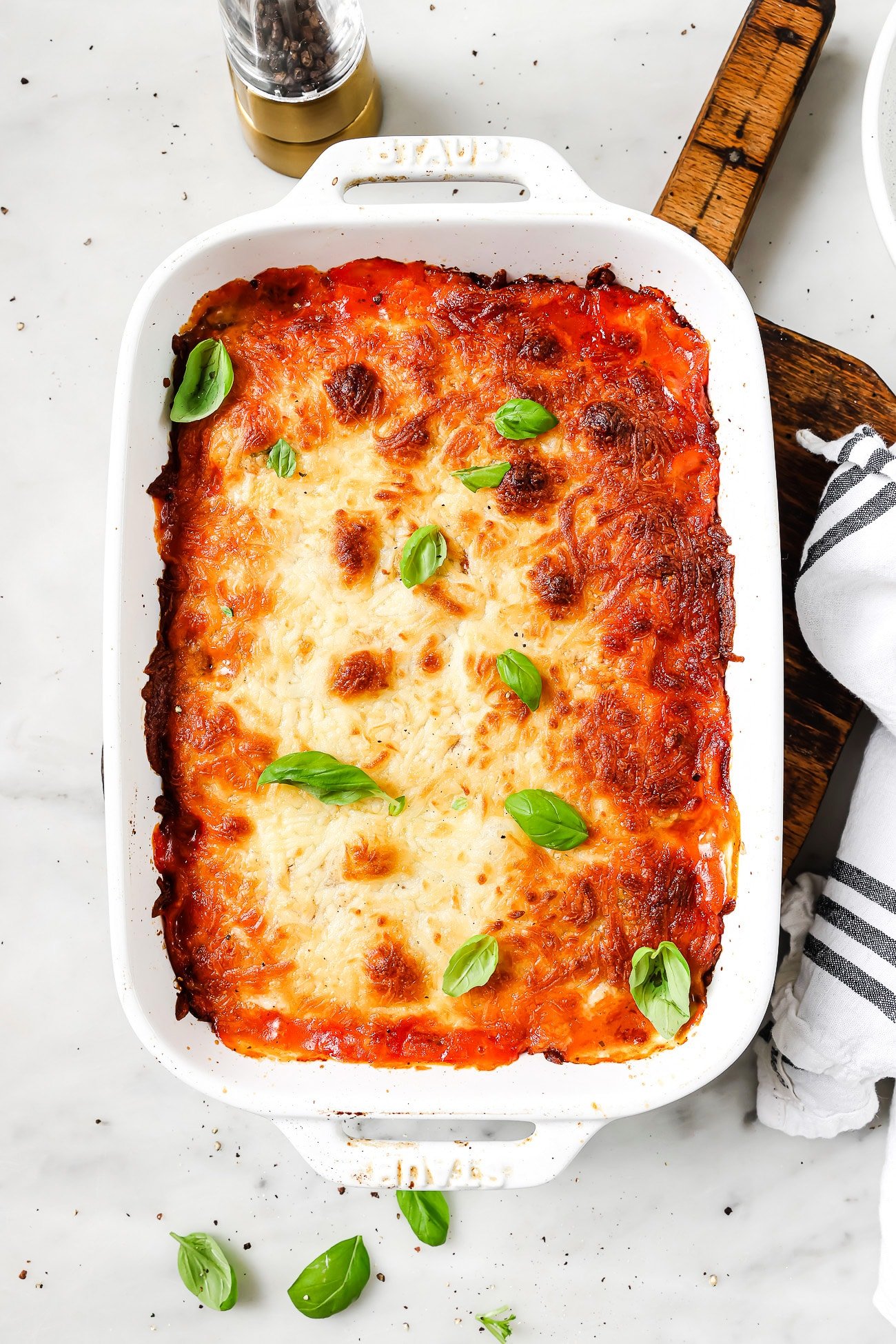 An overhead view of zucchini lasagna rolls in a baking dish.