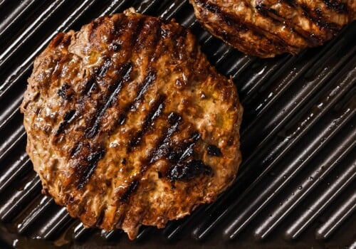 cooked burger patties on a grill.