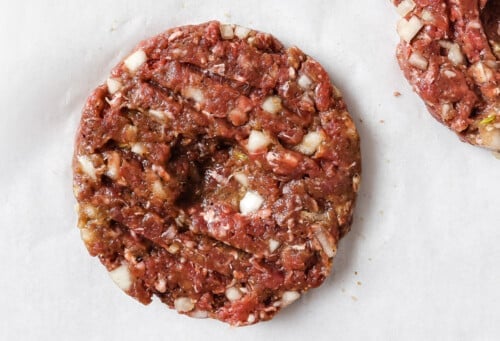 raw burger patties on a parchment paper.