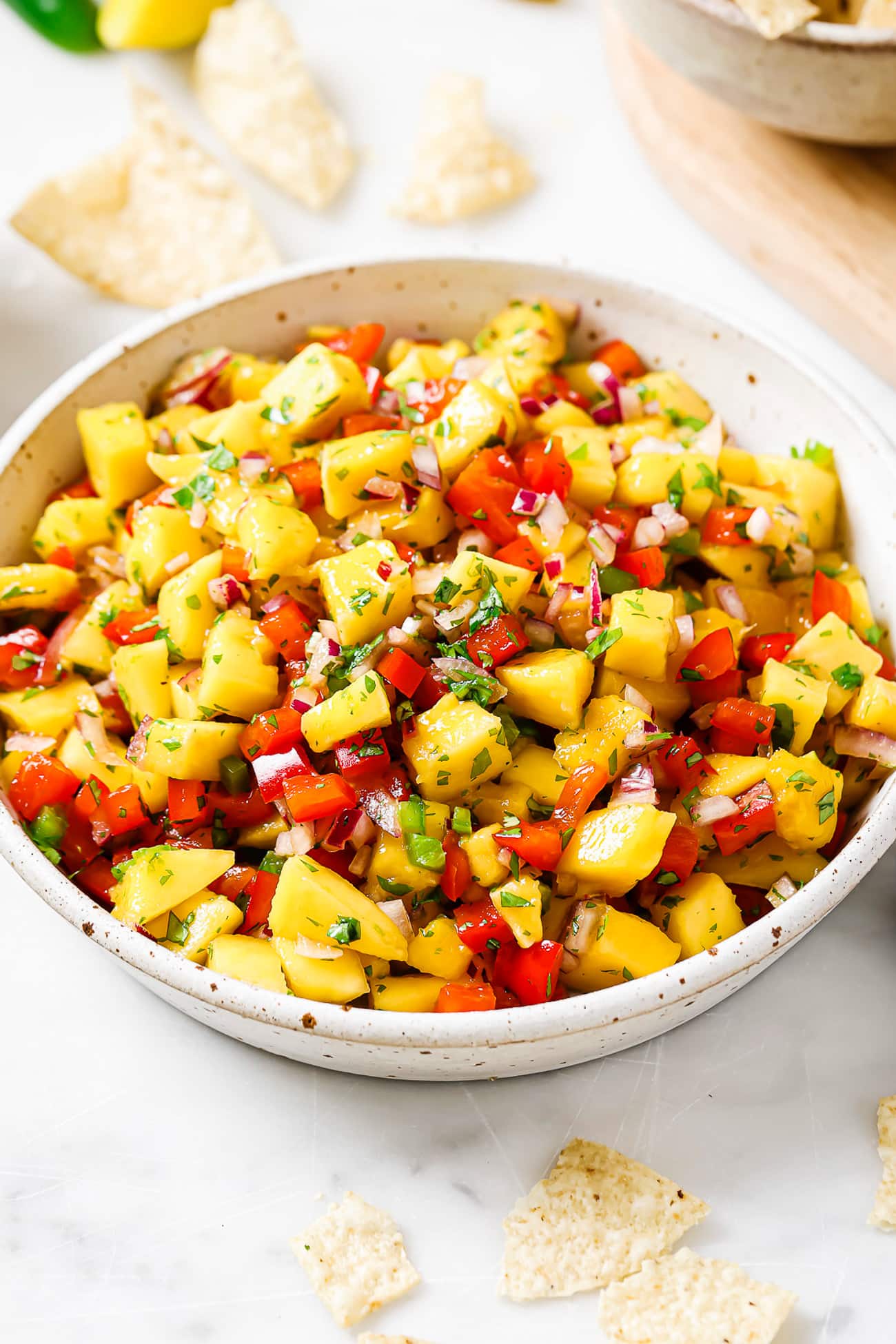 An overhead view of mango salsa in a large white bowl.