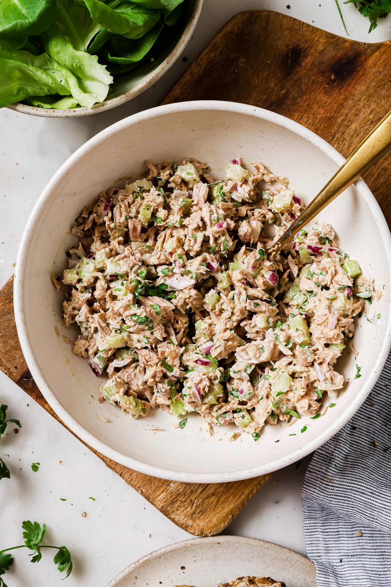 An overhead view of tuna salad in a large white bowl.