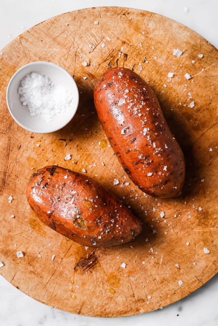 raw sweet potato with olive and salt on a countertop