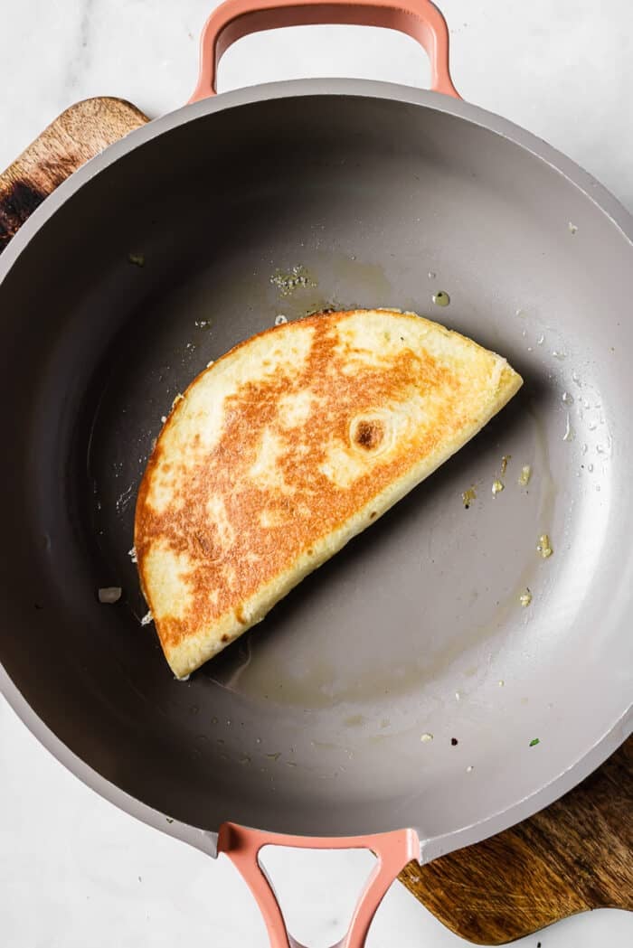 crispy and golden tortillas with carne asada in a skillet.