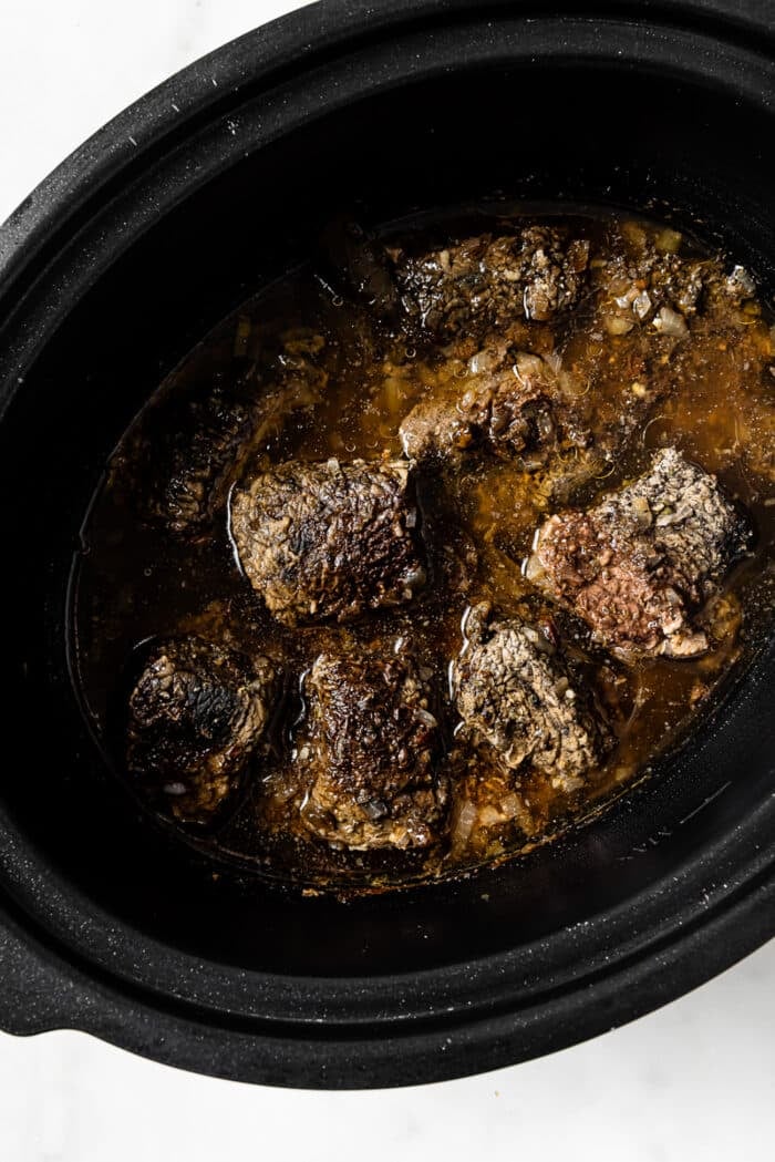 Pieces of cooked beef in the slow cooker. 