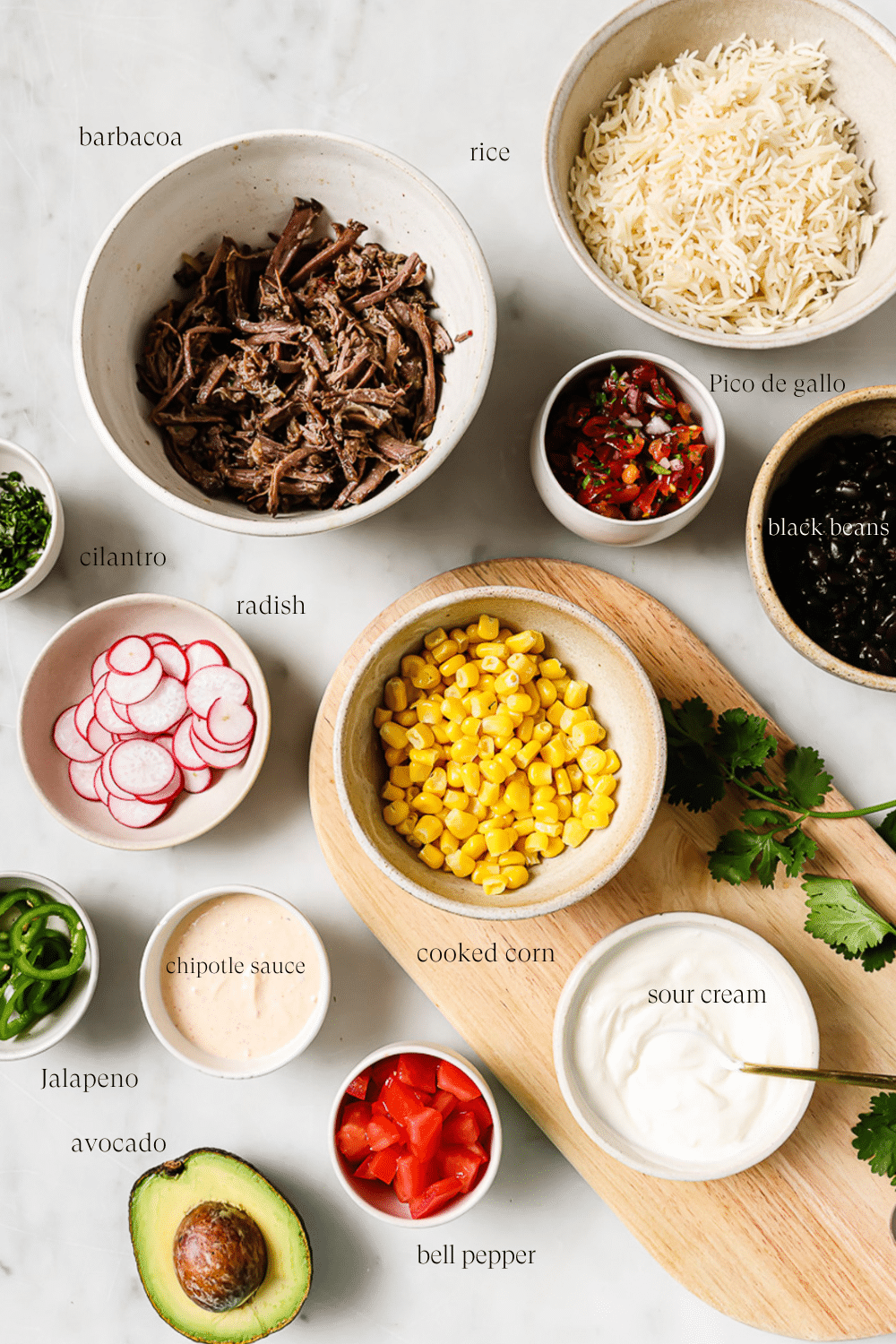An overhead view of prepped ingredients in small bowls.