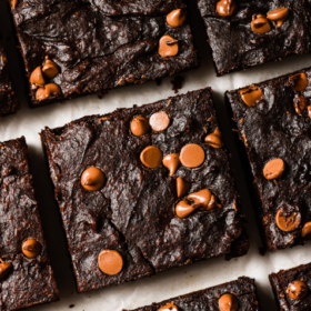 Top-down view of Pumpkin Brownies with chocolate chips on top, arranged in neat rows on a white surface. Text on the image reads Healthy Pumpkin Brownies.