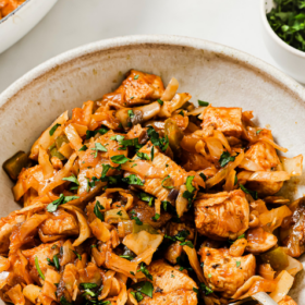 A bowl of cooked chicken pieces mixed with sautéed cabbage, onions, and herbs, garnished with fresh parsley. Text above reads Chicken Cabbage Recipe—a flavorful and easy chicken cabbage recipe perfect for a wholesome meal.