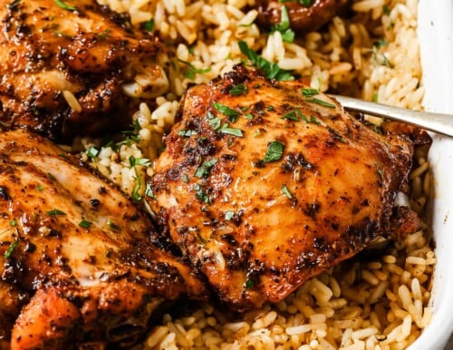 rice and chicken thighs in a white casserole