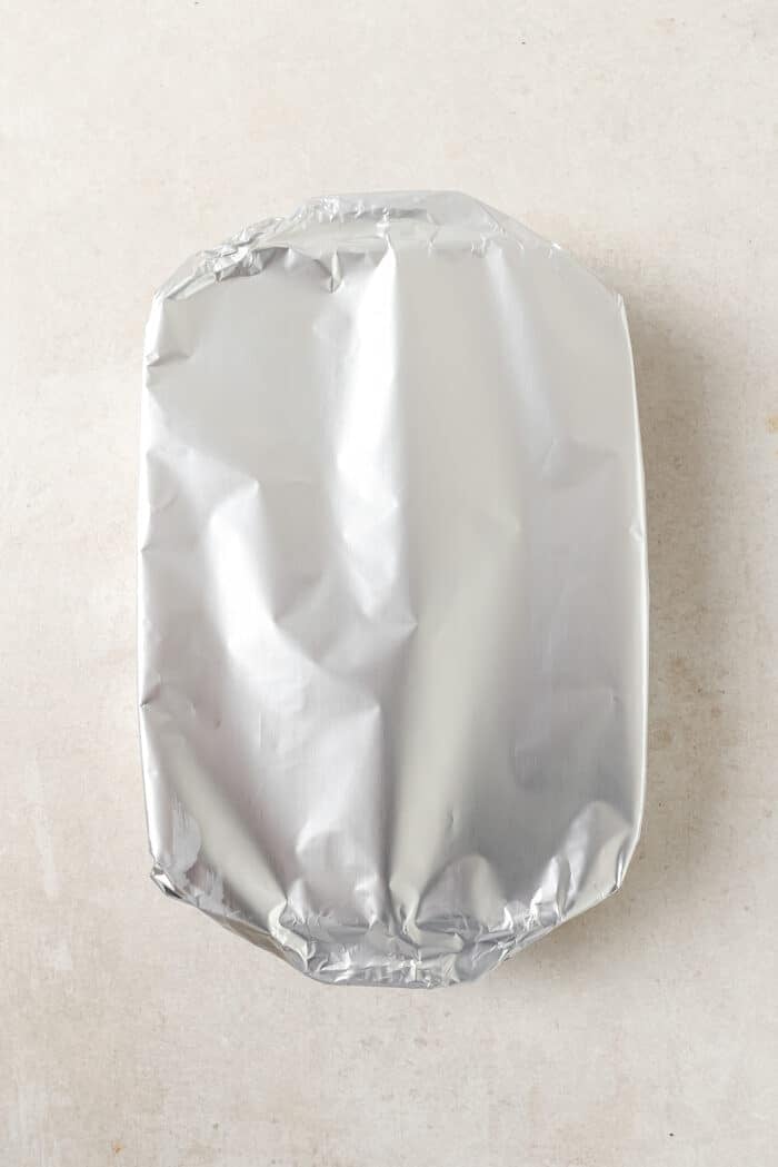 An overhead view of a casserole dish covered in foil.