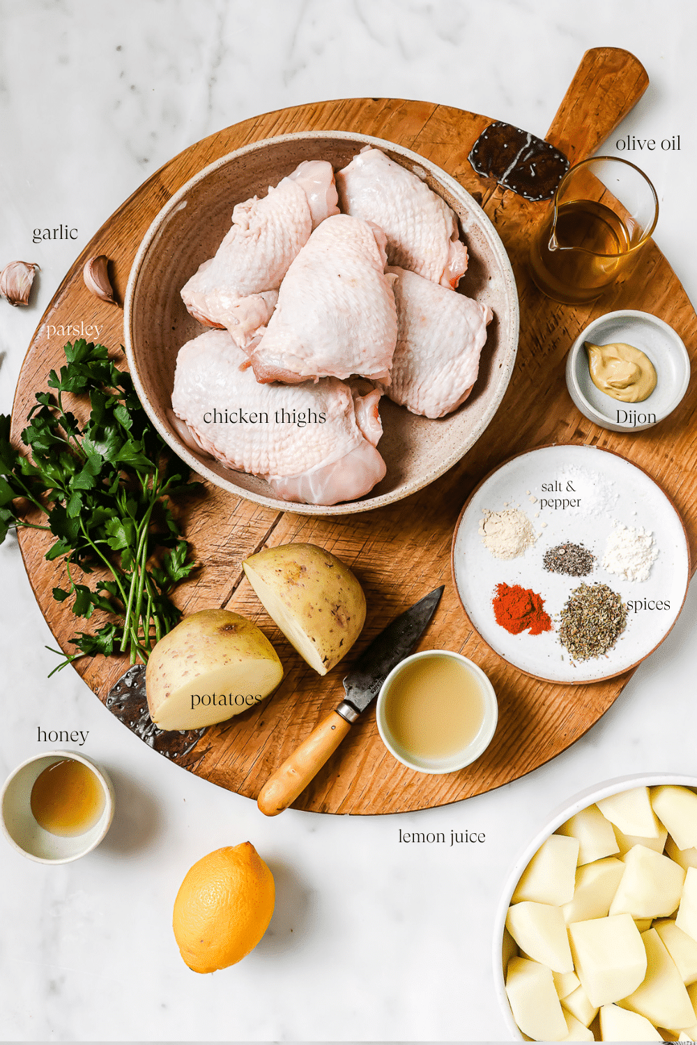 Pre-measured ingredients for Greek chicken and potatoes with text overlay that labels each ingredient.