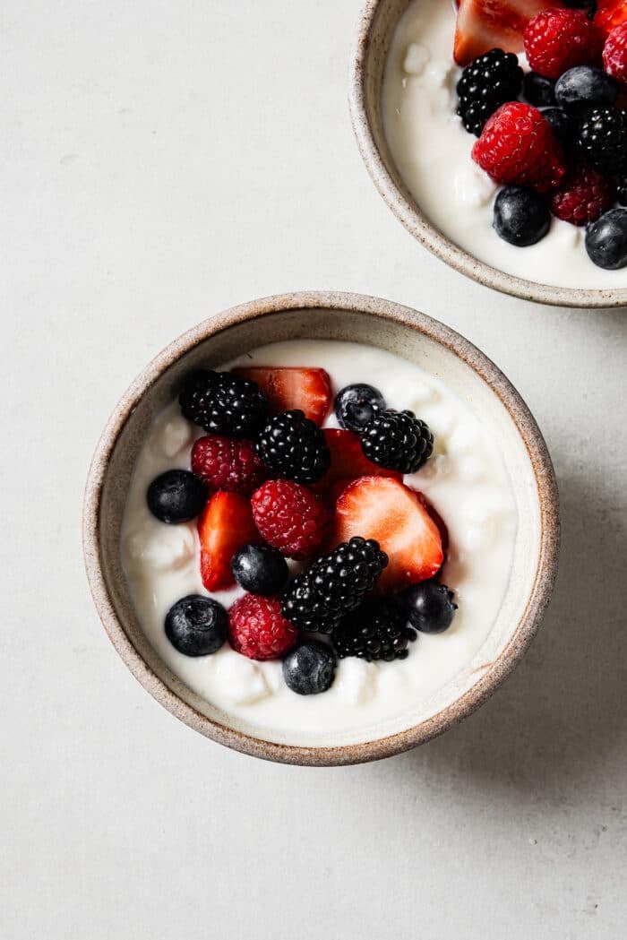 An overhead view of a cottage cheese breakfast bowl topped with mixed berries.