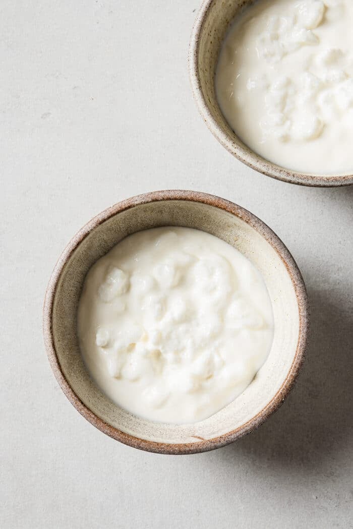 A combination of cottage cheese and Greek yogurt in small serving bowls.