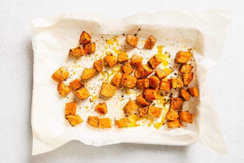 cooked diced sweet potato on a baking sheet.