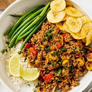 overhead view of Picadillo recipe in a white bowl with green beans and rice