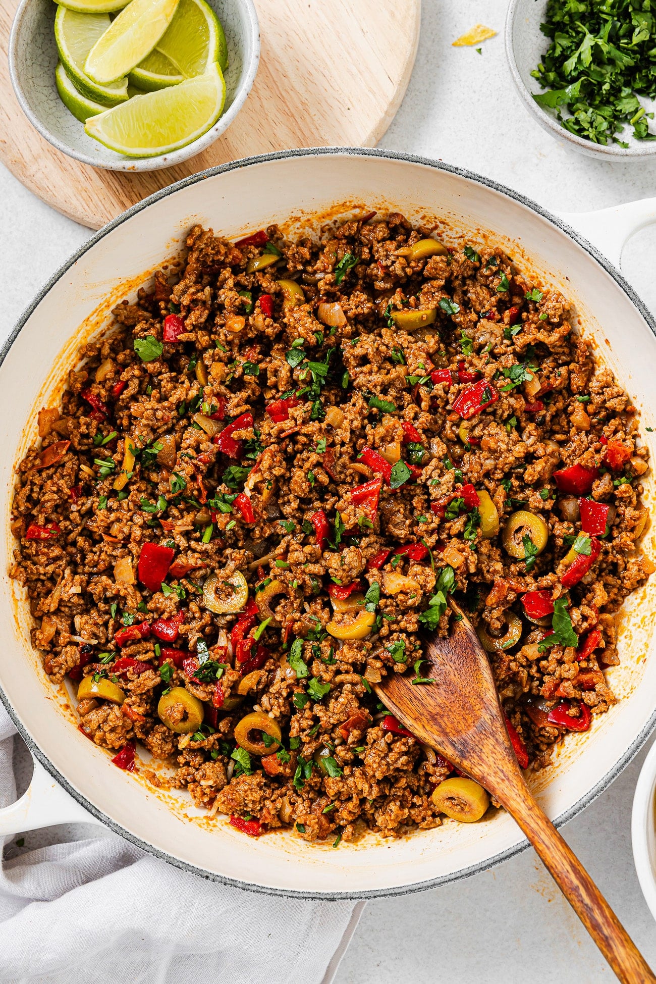 A large skillet of picadillo garnished with fresh cilantro.