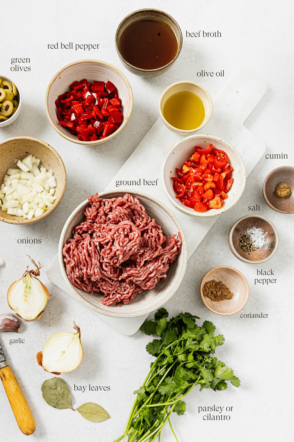 Pre-measured picadillo ingredients in small bowls with text overlay labels.