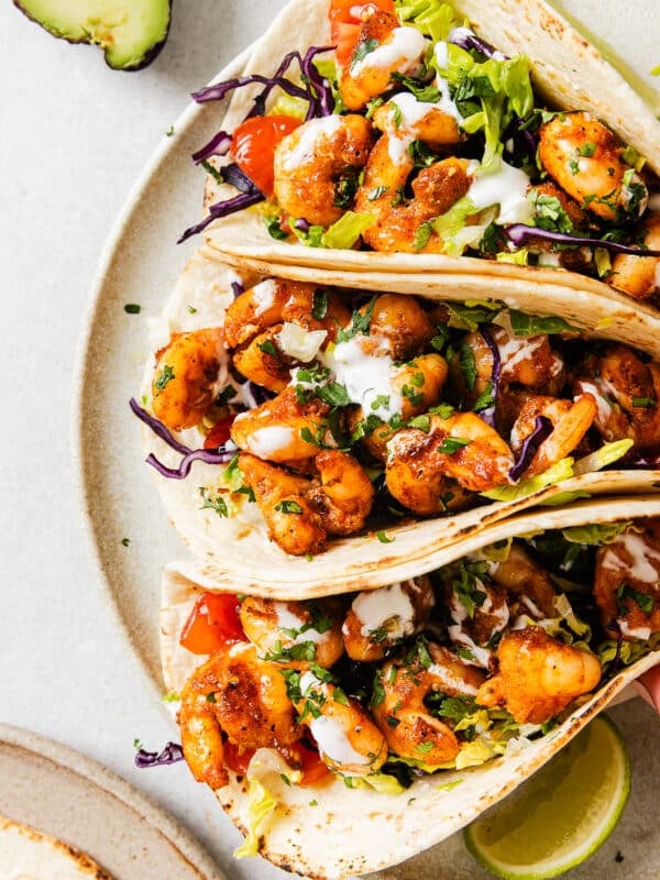 close up of 3 shrimp tacos on a white plate