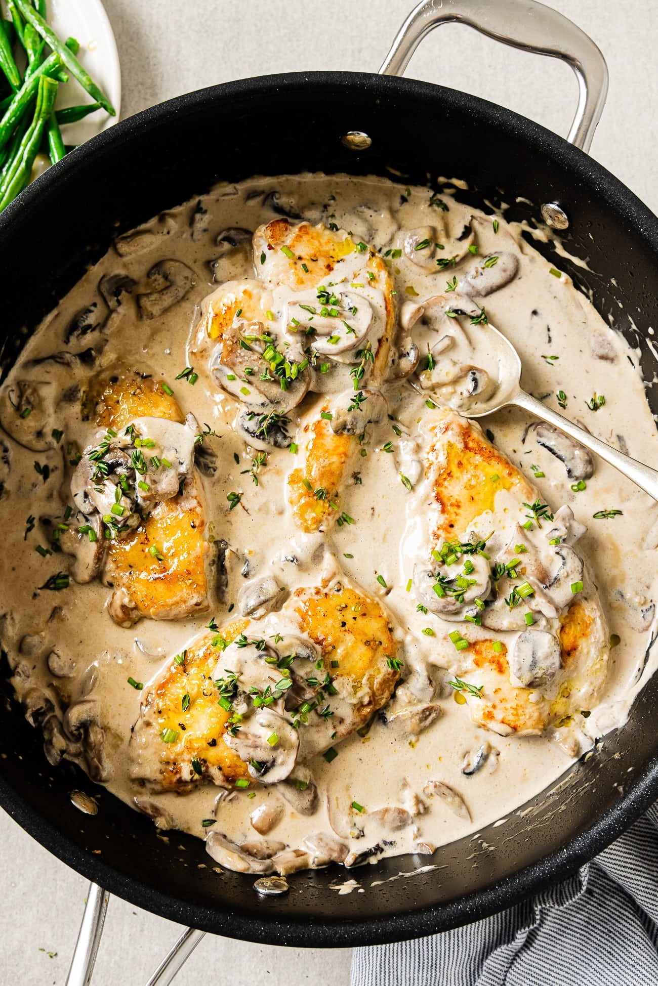 Creamy Mushroom chicken garnished with parsley in a large skillet.