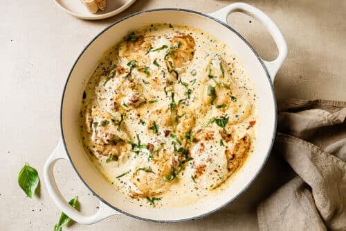Chicken in a creamy sauce in a white skillet