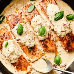 Marry Me salmon in skillet with creamy sun-dried tomato sauce, golden seared fillets