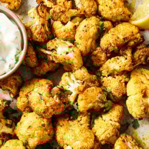 Overhead view of crispy air-fried cauliflower on a white plate.