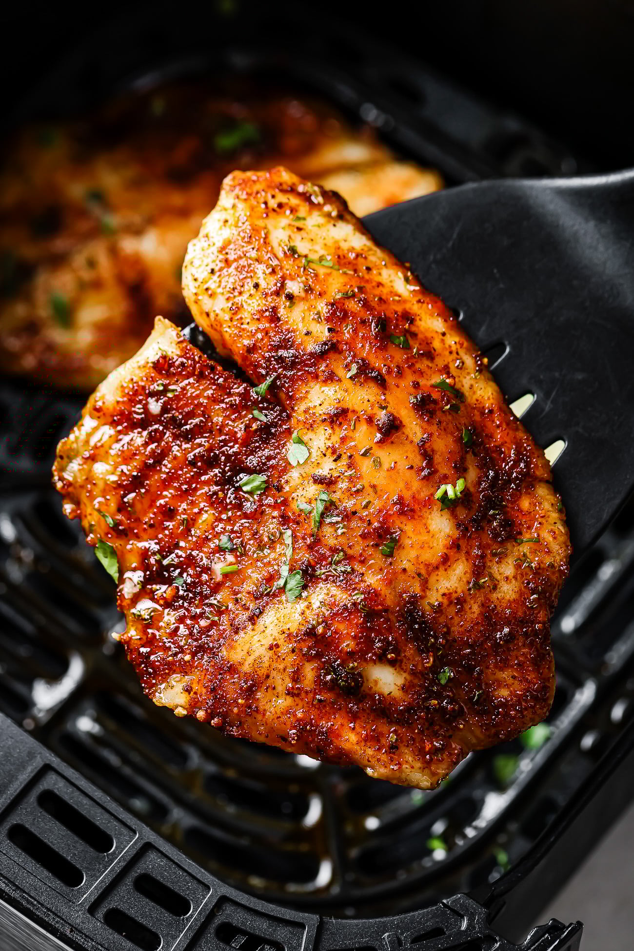 Close-up of an air fryer tilapia fillet on a spatula.