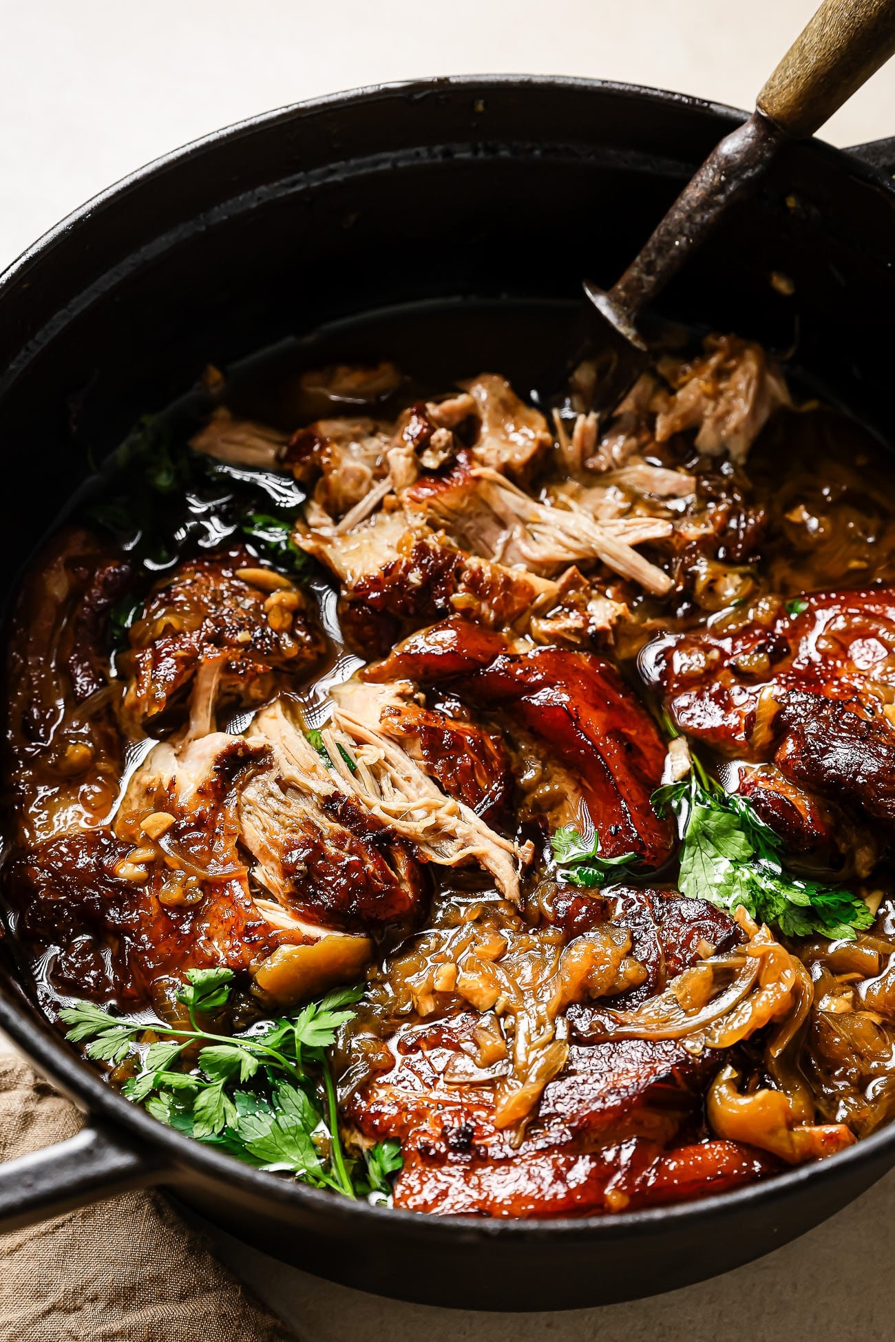 Close-up of Apple Cider Braised Pork Shoulder in a black Dutch oven.