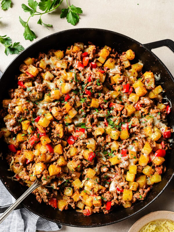 Overhead view of ground beef and potatoes cooked in a cast-iron skillet.
