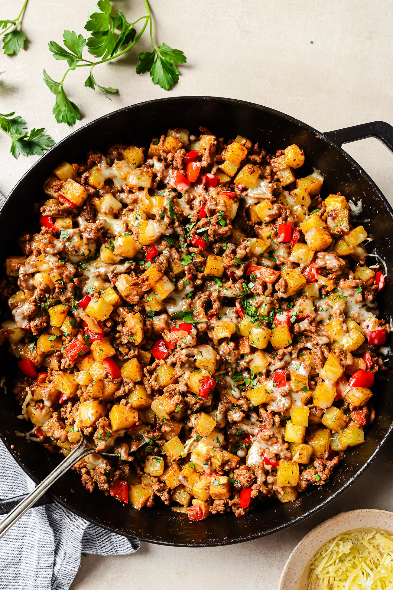 Overhead view of ground beef and potatoes cooked in a cast-iron skillet.