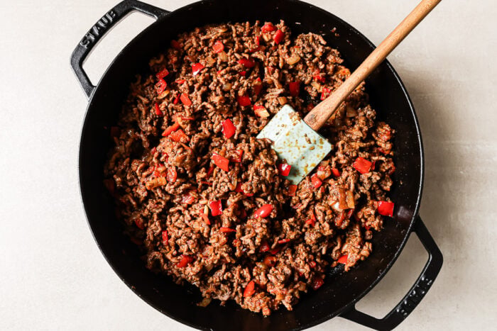 Overhead view of cooked ground beef and vegetables in a cast-iron skillet.