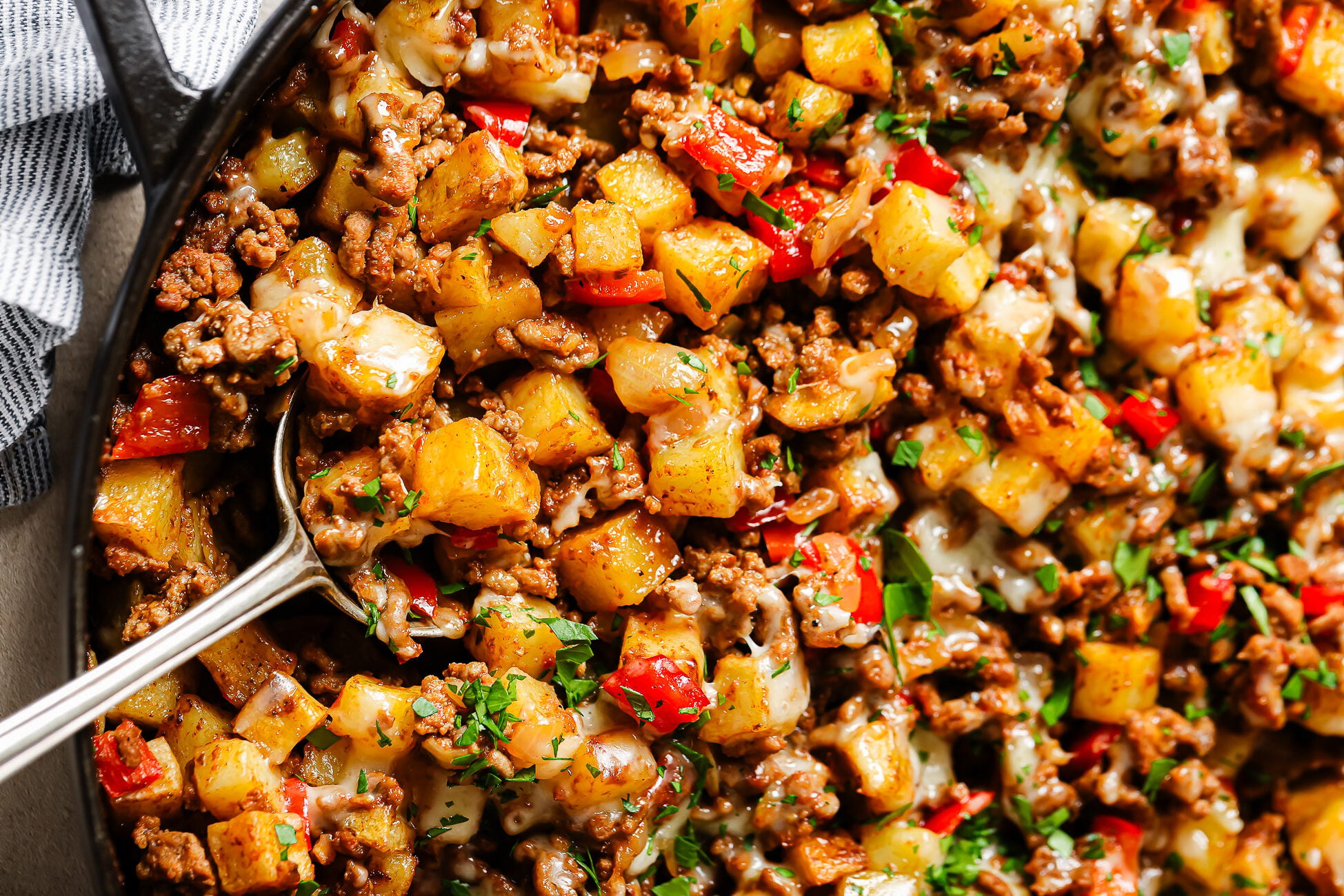 Close-up of ground beef and potatoes in a cast-iron skillet.
