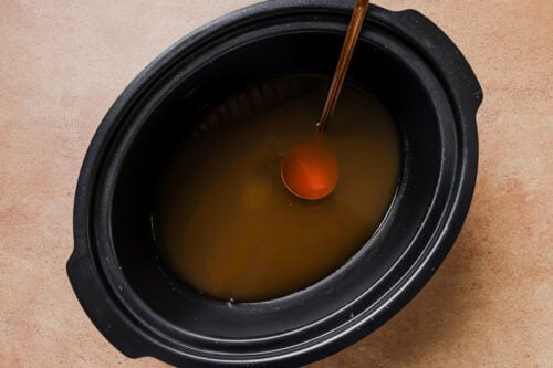 Homemade apple cider in a slow cooker bowl.
