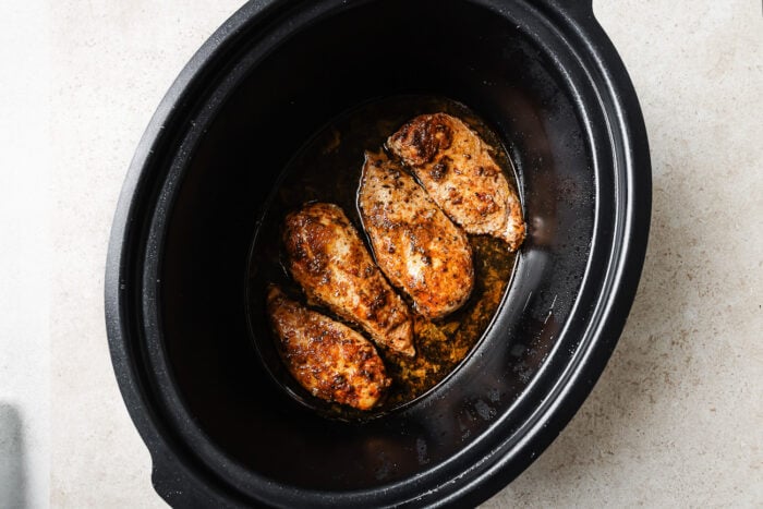 closeup of slow cooker chicken breast inside of a slow cooker.