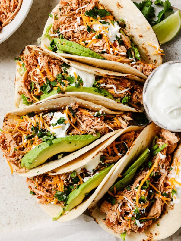Slow Cooker Chicken Tacos with fresh toppings on a kitchen countertop.