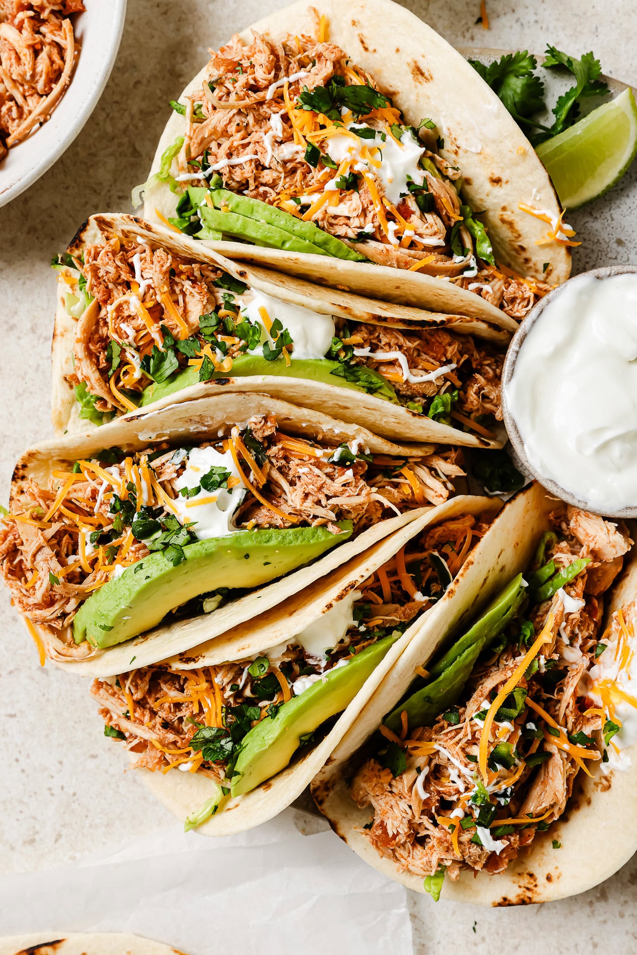 Slow Cooker Chicken Tacos with fresh toppings on a kitchen countertop.