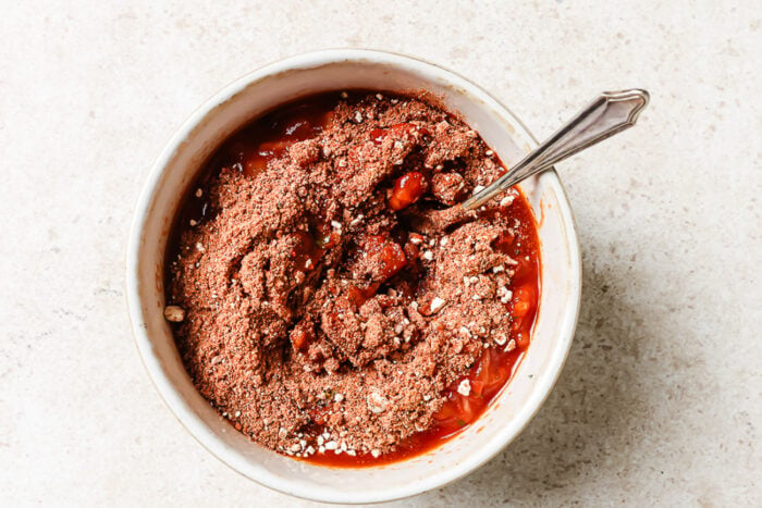 Tomato sauce blended with herbs and spices in a white bowl, ready to cook.