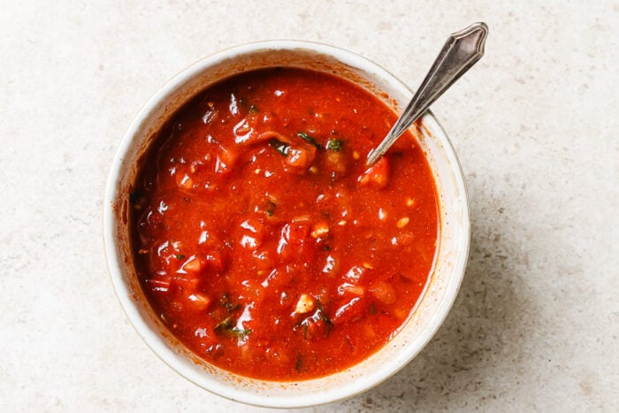Tomato sauce blended with herbs and spices in a white bowl, ready to cook.