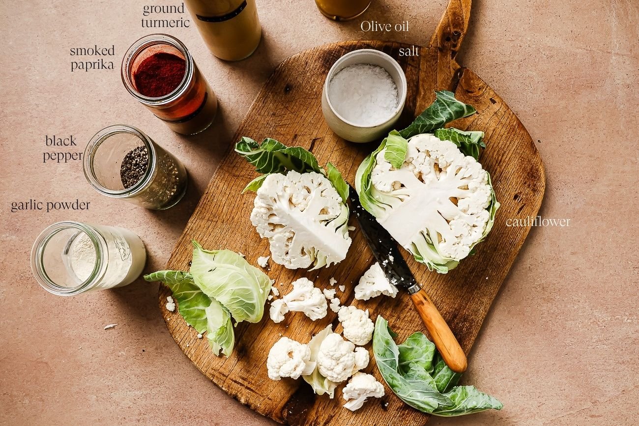 ingredients to make air fryer cauliflower on a wooden board.