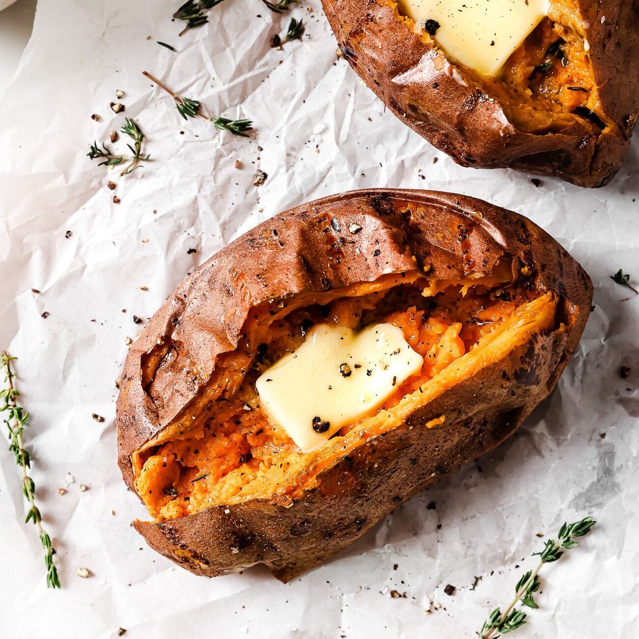 overhead view of Air Fryer Baked Sweet Potato on a countertop and parchment paper. 