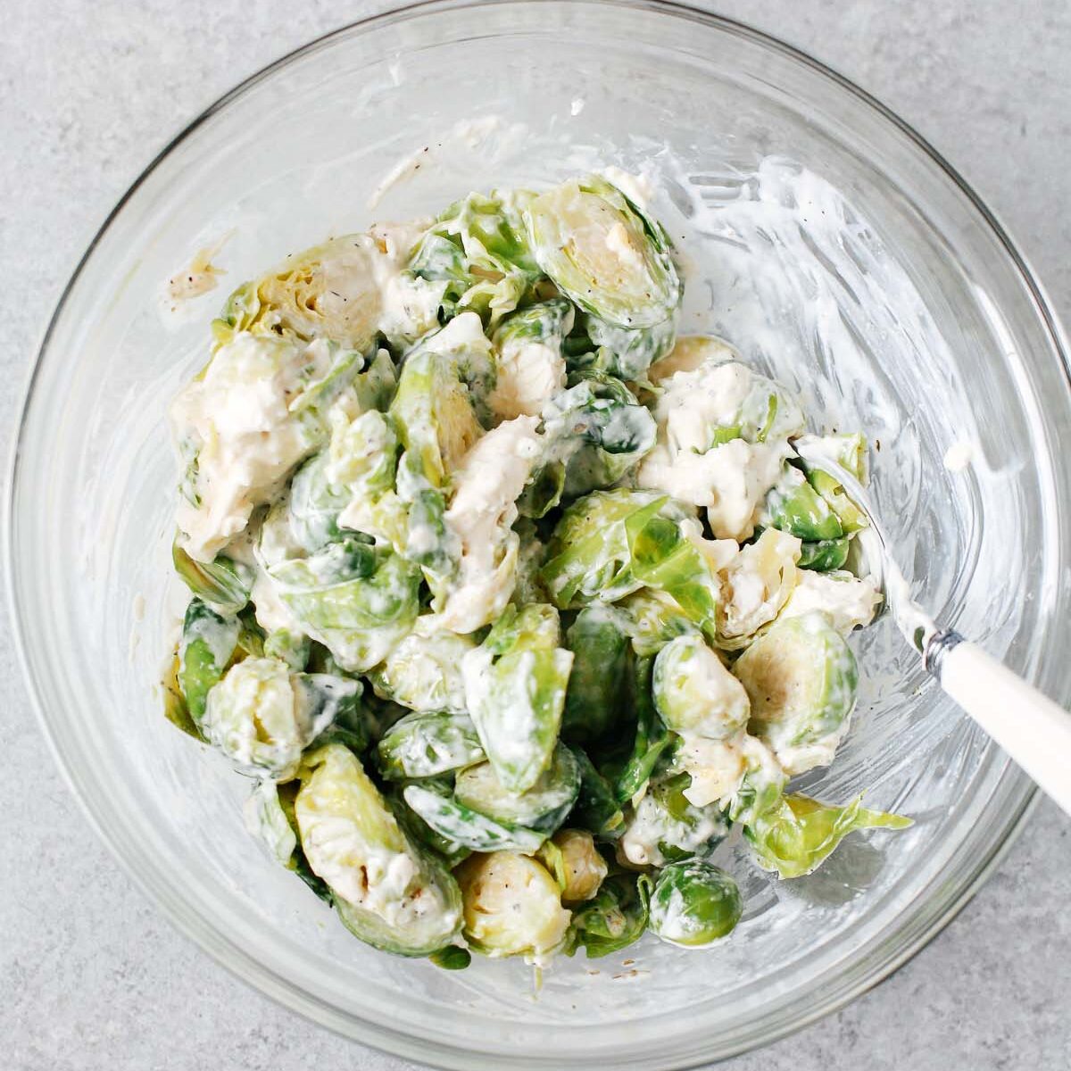 brussels sprouts with cheese mixture in a glass bowl.