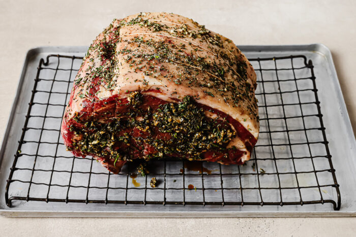 seasoned roast on a wire rack set inside a baking sheet.