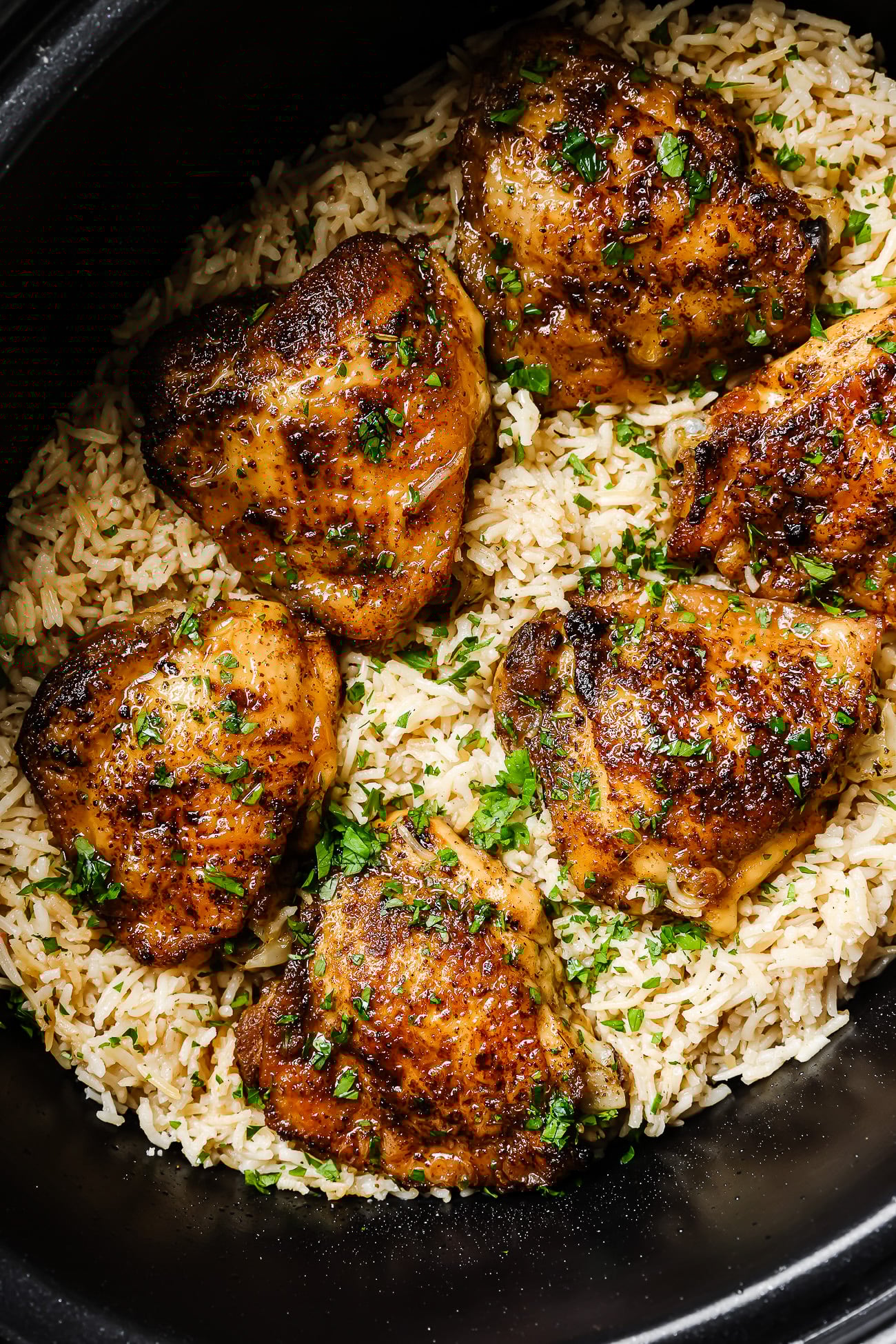 closeup of chicken and rice inside of a slow cooker bowl.