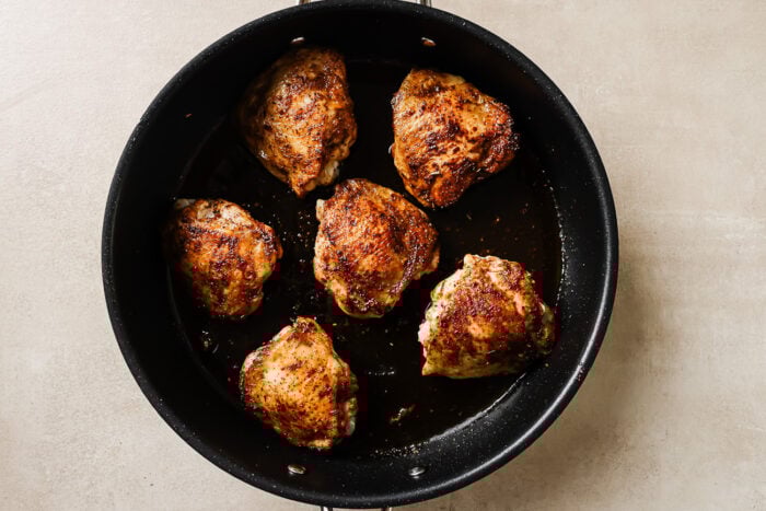 cooked chicken thighs in a cast iron skillet.