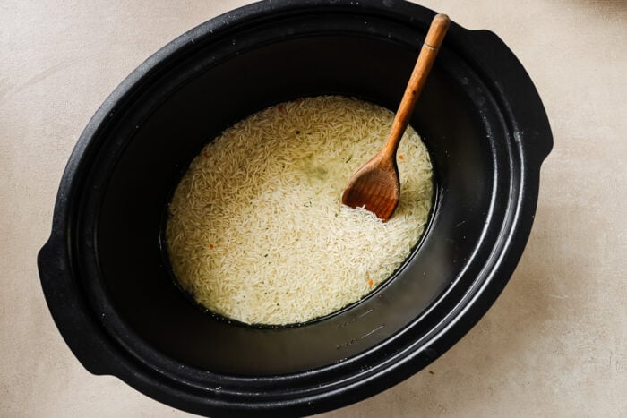 overhead view of uncooked rice in a slow cooker pot.