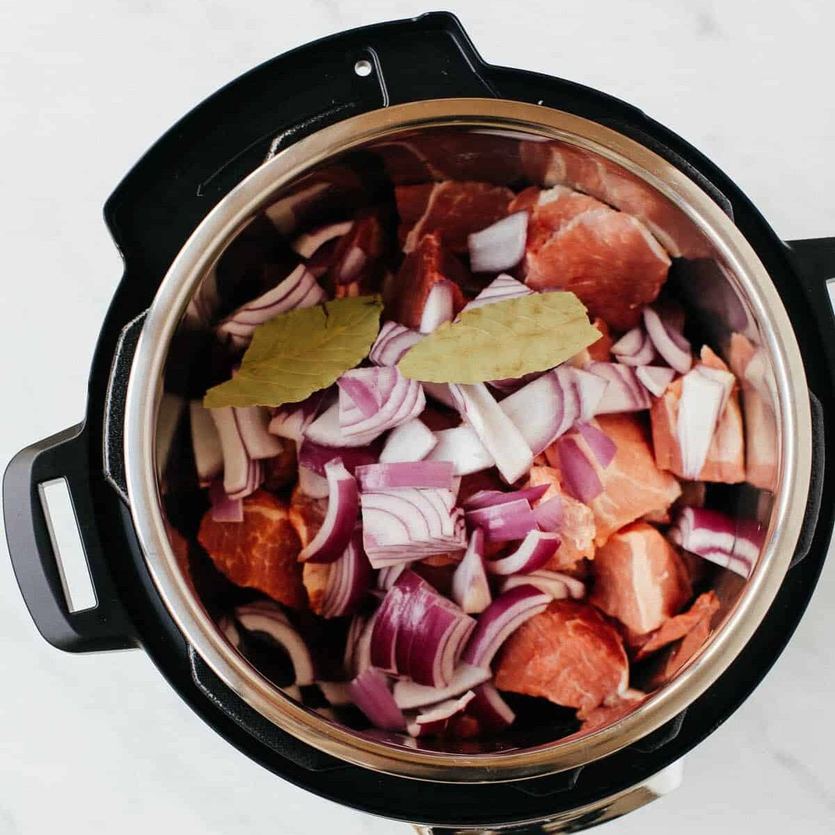 overhead view of instant pot containing pork shoulder bites