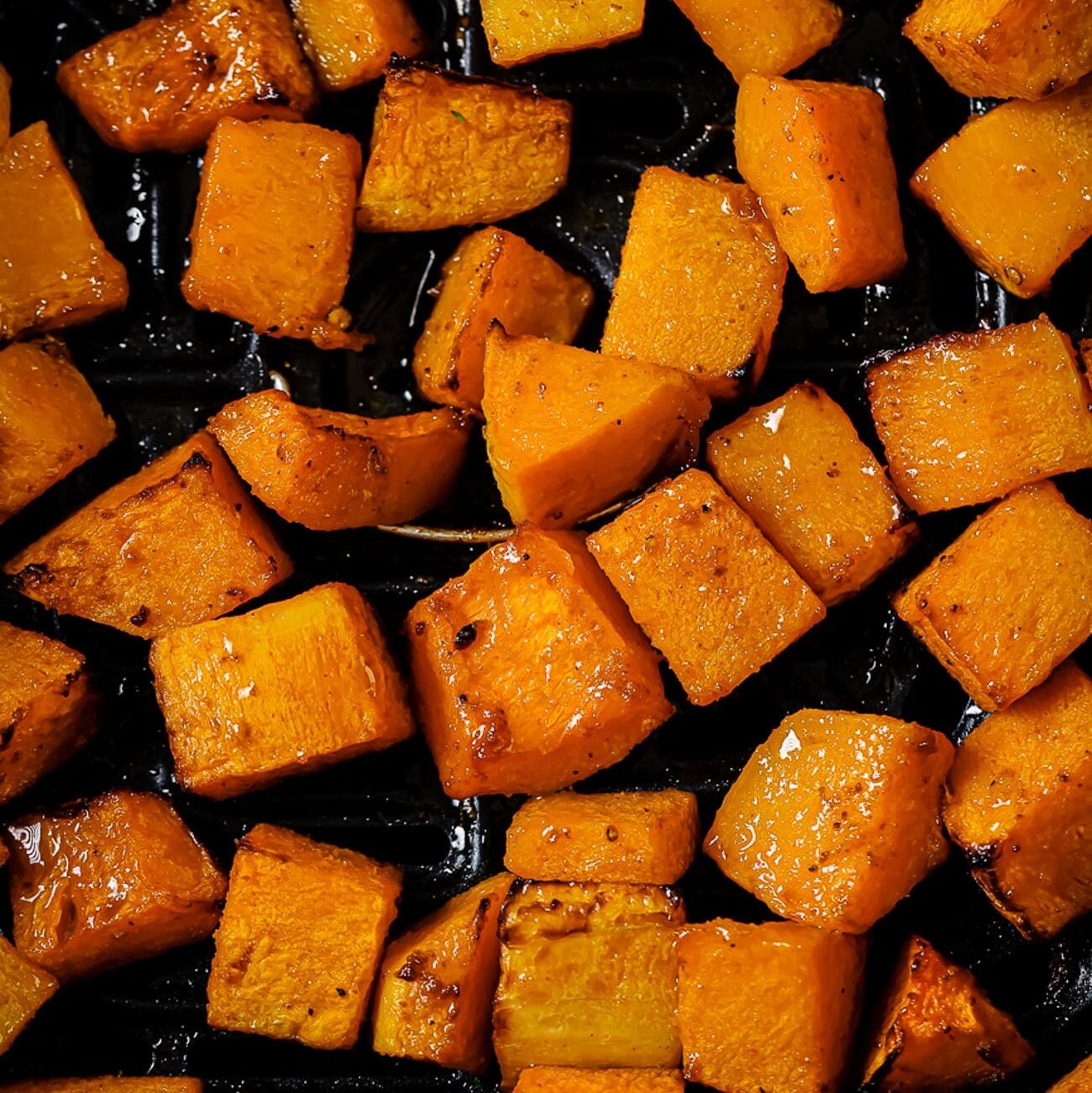 A close-up of air fryer butternut squash in the air fryer basket.