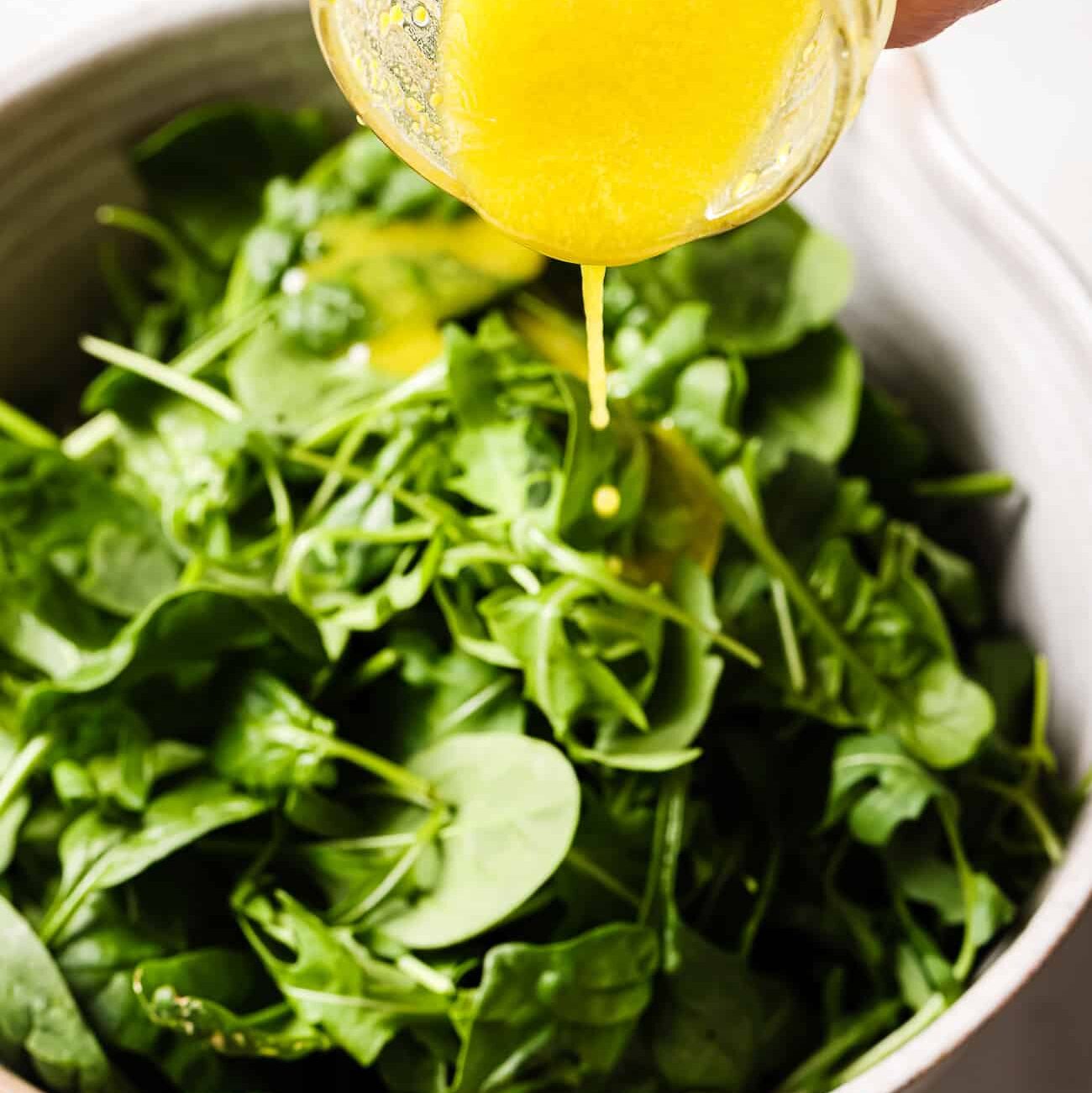 A bowl of mixed greens tossed with homemade salad dressing.