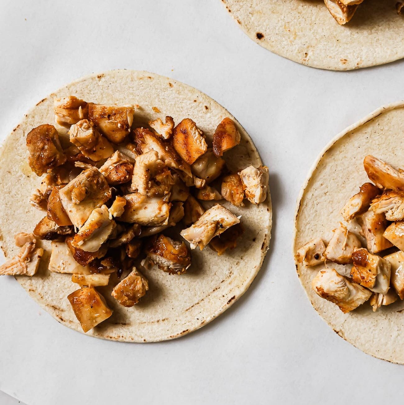 Diced chicken piled on top of warm corn tortillas.