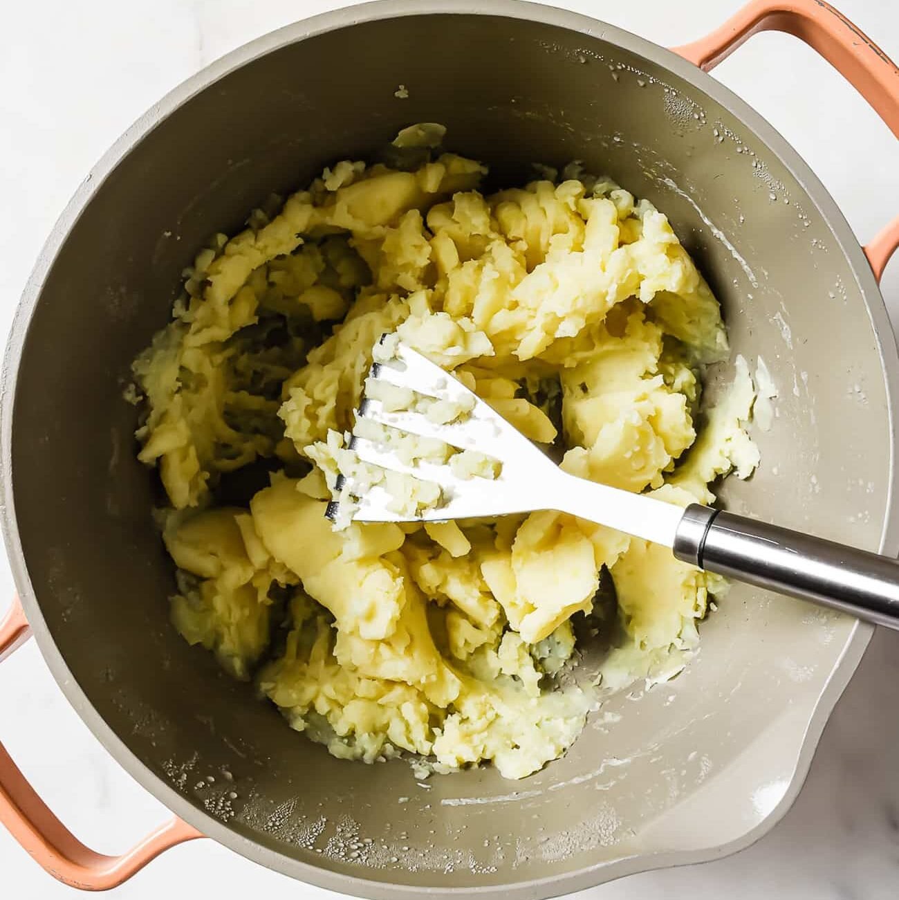 A large pot of mashed potatoes on a white countertop.