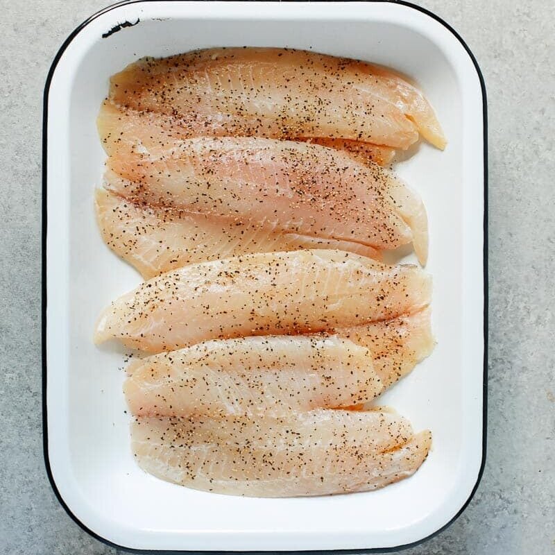 raw tilapia in a baking sheet